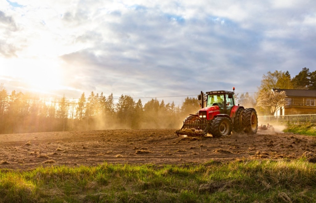 Bilden visar en traktor på en åker.